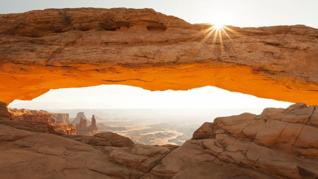 The underside of Mesa Arch basks in a morning glow in Canyonlands National Park. Picture: Lonely Planet/Phillip Lee Harvey.