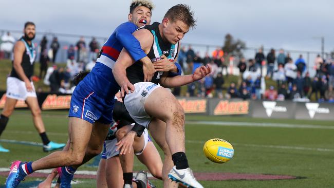 Ollie Wines gets a kick away despite pressure from Western Bulldog Jason Johannisen. Picture: Michael Klein