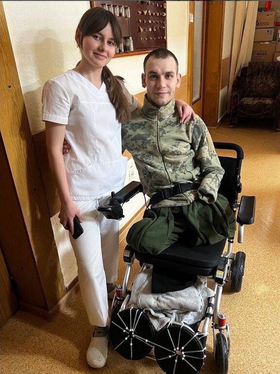 Denys Kryvenko, who has lost both legs and an arm, with a medic following surgery in a military hospital in Vinnytsia, Ukraine. Picture: Denys Kryvenk