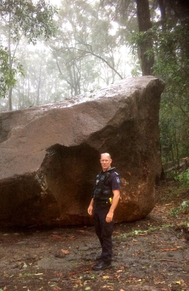 A police officer in front of one of the boulders. Picture: QLD Police