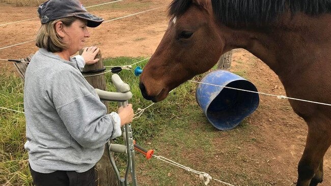 Moira Davis, 57, pictured hobbling on crutches, says her leg and ankle never fully healed after she fell from a horse bridge at an Equestrian Victoria event in 2018. Picture: Supplied