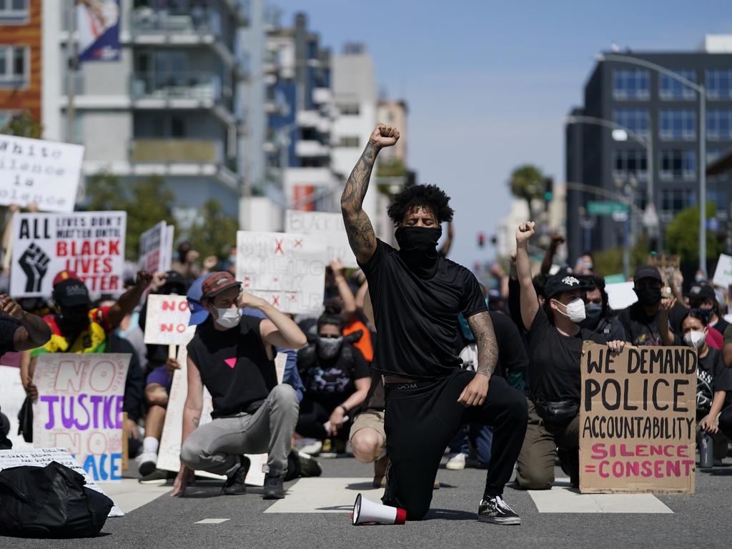 Demonstrators kneel in a moment of silence outside the Long Beach Police Department on Sunday. Picture: Ashley Landis/AP