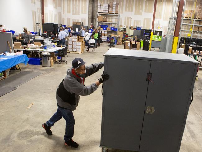 A Fulton County employee moves voting machine transporters to be stored at the Fulton County Election Preparation Center. Picture: Getty Images.