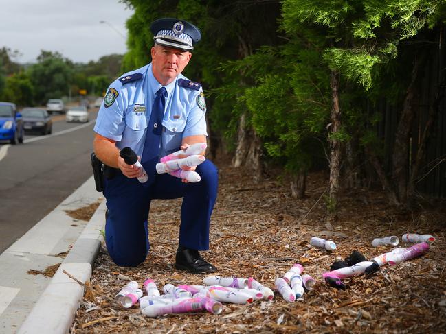 Hills District Police Superintendent Rob Critchlow with discarded Rexona cans found at the side of a road in Kellyville.