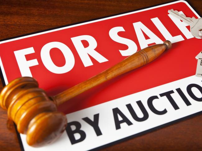 "Home for Sale by Auction. For Sale sign with auctioneeraas gavel and a chrome house key fob, with house key. Copy space."