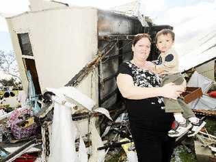 Alison Kaihhau and her 22-month-old son Tane of Kyogle with demolished caravan owned by Alison’s parents, also of Kyogle. . Picture: Jay Cronan