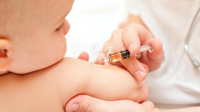 Doctor giving a child an intramuscular injection in arm.