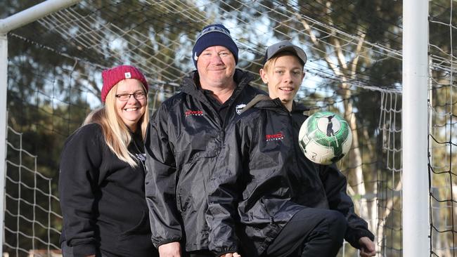 Para Hills Soccer Club is raising money and awareness for brain cancer, in support of club junior assistant coach Shane Hillman, who is terminally ill with the disease. Shane with his 15-year-old son Josh and wife Deb at Para Hills Soccer club, 9 June 2018. (AAP Image/Dean Martin)