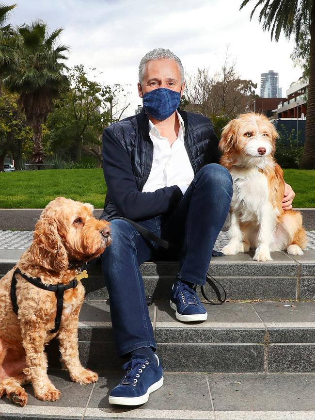 Telstra CEO Andy Penn stops for a break while walking his dogs Mr Bennett (left) and Wolsely in Prahran. Picture: Aaron Francis