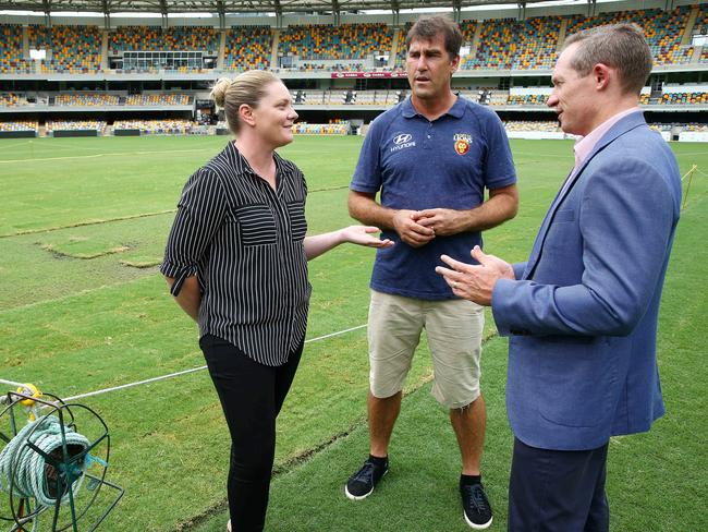 AFLW chief executive Bree Brock and Brisbane women’s coach Craig Starcevich, with Minister for Sport Mick DeBrenni, discuss the grass repair at the Gabba. Picture: Liam Kidston.