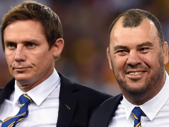 (FILES) This file photo taken on June 11, 2016 shows Australia's coach Michael Cheika (R) standing with assistant coach Stephen Larkham before Australia plays England in their international rugby union match in Brisbane.   Wallabies coach Michael Cheika says he will likely quit if he fails to lead Australia to victory at the World Cup in Japan in 2019. Australia lost the 2015 London final to the All Blacks and the 50-year-old said on February 28, 2018 he has set himself a win-or-walk ultimatum in Japan, with making the decider again not enough to sway him to give it one more crack in 2023. / AFP PHOTO / William WEST / -- IMAGE RESTRICTED TO EDITORIAL USE - STRICTLY NO COMMERCIAL USE --