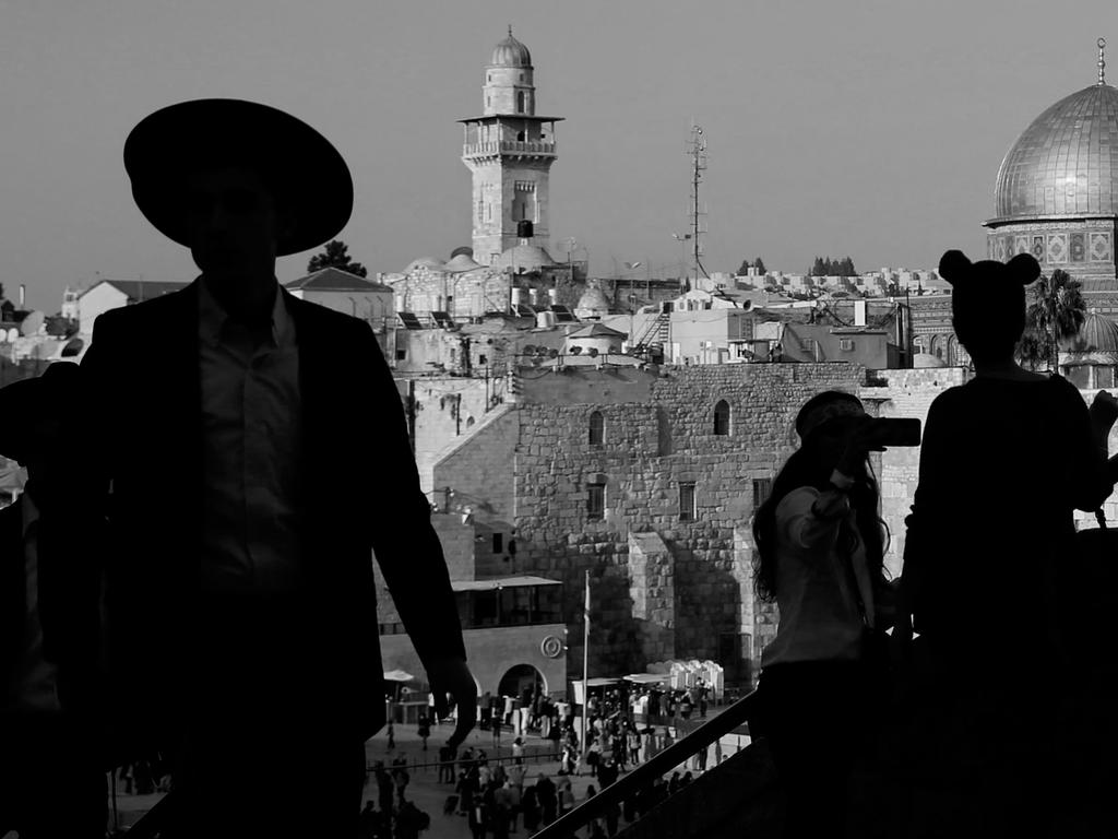 An Ultra-Orthodox Jewish man stands with tourists at the Jewish quarter in Jerusalem’s Old City overlooking the Dome of the Rock mosque. Picture: AFP