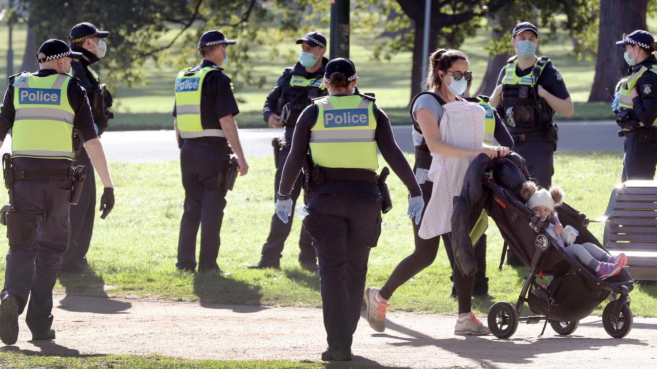 A walker goes past a large group of police officers on Friday. Picture: NCA NewsWire/David Crosling