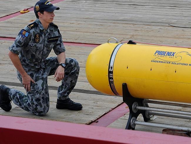 Underwater device ... Able Seaman Matthew Tranter-Edwards kneels alongside the Phoenix Autonomous Underwater Vehicle ‘Artemis’ Bluefin-21, on the deck of the Australian navy ship Ocean Shield. Picture: AFP