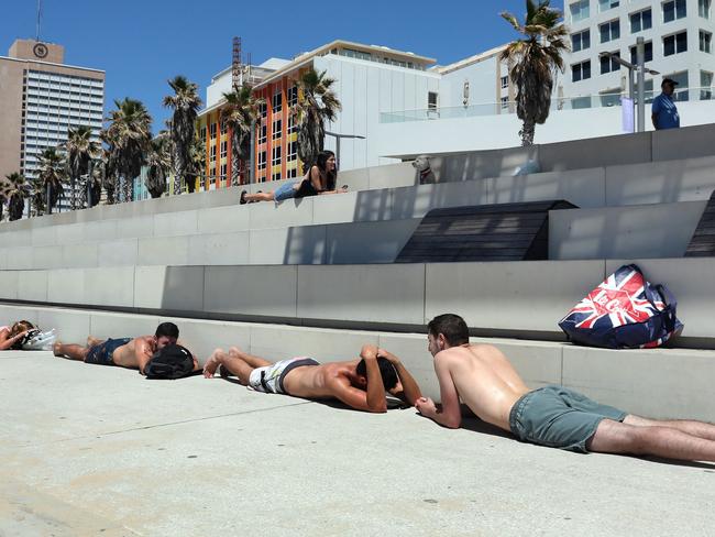 Israeli beachgoers take cover in the central city of Tel Aviv as rockets were launched over the Gaza Strip. Picture: AFP