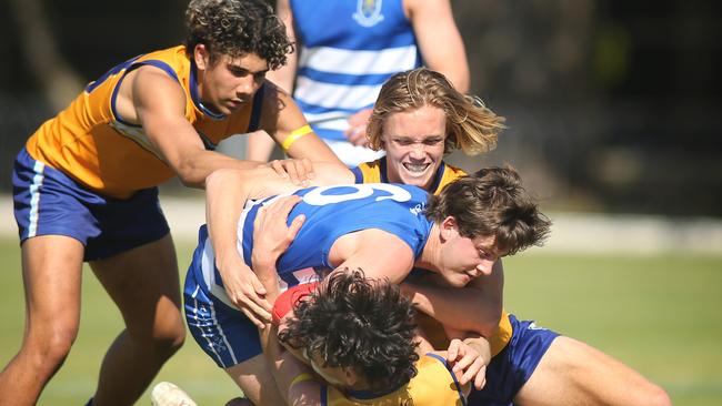 Sacred Heart’s Kobe Ryan (back), and Lachlan Scannell (bottom), tackle St Peter’s Malachy Carruthers. Picture Dean Martin