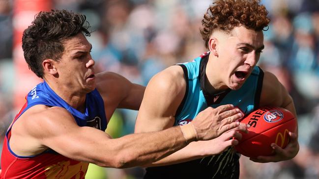 ADELAIDE, AUSTRALIA - JUNE 22: Logan Evans of the Power is tackled by Cam Rayner of the Lions during the 2024 AFL Round 15 match between the Port Adelaide Power and the Brisbane Lions at Adelaide Oval on June 22, 2024 in Adelaide, Australia. (Photo by James Elsby/AFL Photos via Getty Images)