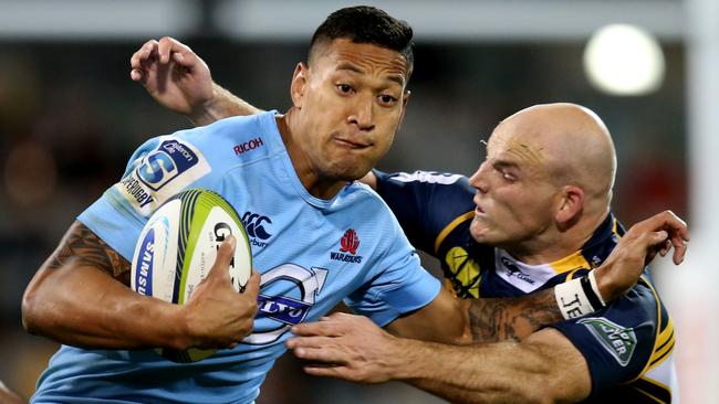 Brumbies captain Stephen Moore tackles Waratah Israel Folau.