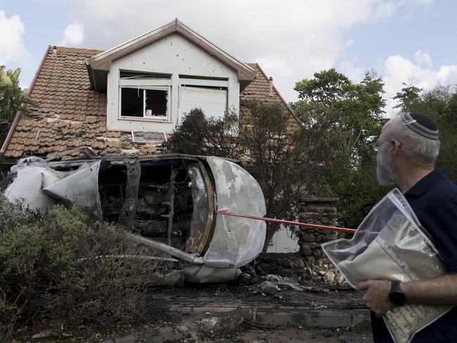 MORESHET, ISRAEL - SEPTEMBER 22: A man walks with prayer talit at a scene of a house that was hit by a rocket fired from Lebanon on September 22, 2024 in Moreshet, Israel. Hezbollah claimed to have attacked military targets inside Israel, with some landing near the city of Haifa. (Photo by Amir Levy/Getty Images)