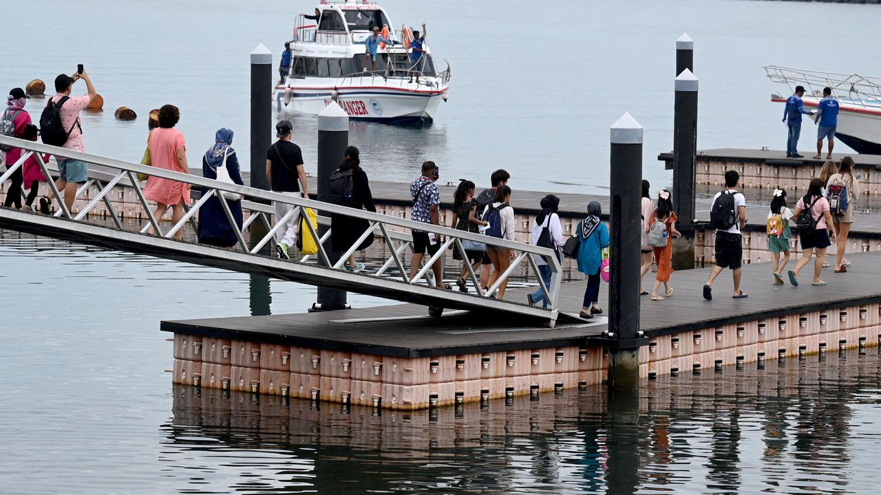 Tourists walk towards passenger ferries to travel from Sanur to Nusa Penida island. Picture: Sonny Tumbelaka / AFP