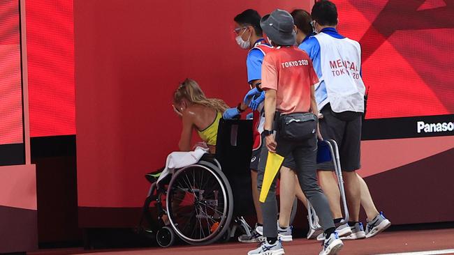 Genevieve Gregson leaves in a wheelchair after the women's 3000m Steeplechase. Picture: Adam Head