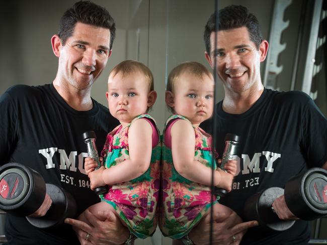 Nic Castle works out with his 17-month-old daughter, Eve, at RecWest fitness centre in Footscray. Picture: Jay Town