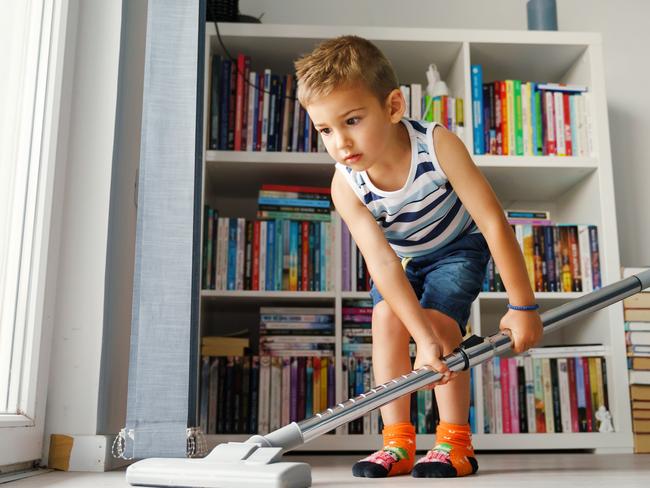 Little kid using vacuum cleaner at home - Small boy cleaning floor in apartment - Child doing housework having fun - side view full length in summer day - childhood development real people concept