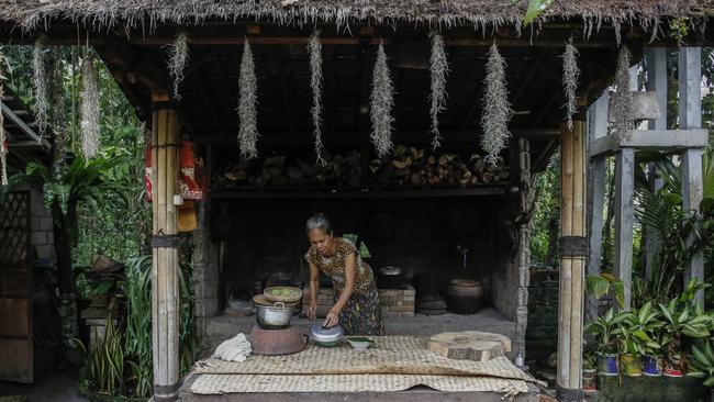 Ni Wayan Tagel prepares Lak-lak, a traditional Balinese dessert, using firewood stove in Warung Harmony at Taman Bali Village, Bangli Regency, Bali. Picture: Johannes P. Christo