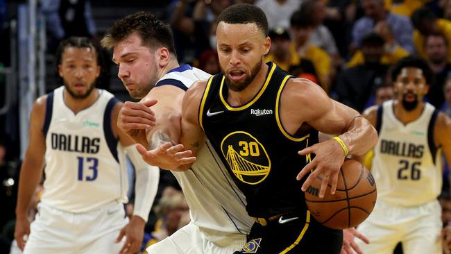 Stephen Curry of the Golden State Warriors fights for the ball against Luka Doncic of the Dallas Mavericks. Photo by Harry How/Getty Images