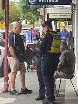 Police speak with witnesses as alleged headbutt victim David Winter recovers on a chair. Picture: supplied