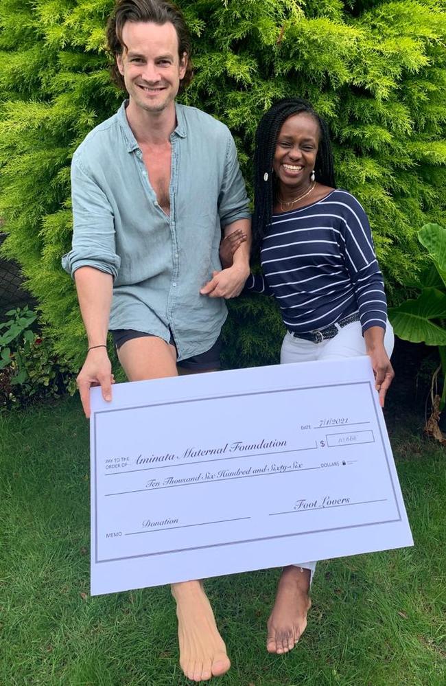 Australian actor Luke Cook raises $10,000 for charity by selling pictures of his feet online. Here, he presents a cheque to Aminata Conteh-Biger.