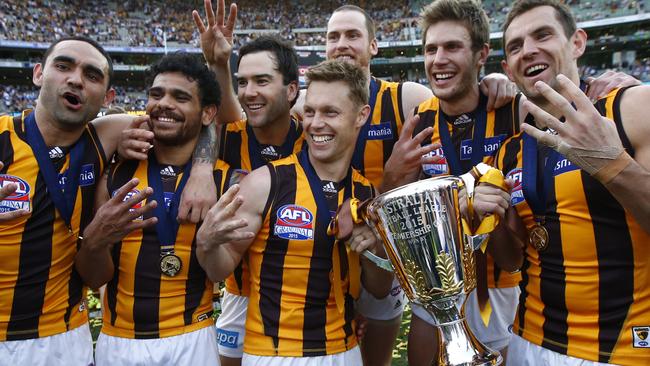 Skipper Luke Hodge (far right) celebrates Hawthorn’s third straight flag in 2015.