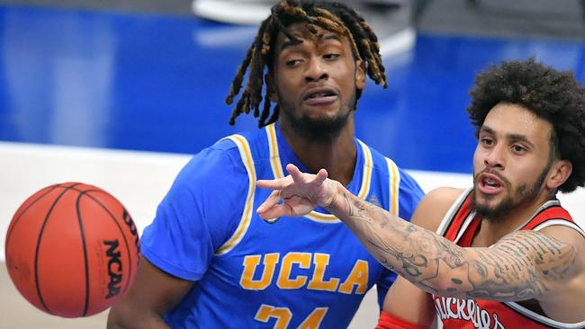 CLEVELAND, OHIO - DECEMBER 19: Duane Washington Jr. #4 of the Ohio State Buckeyes passes around Jalen Hill #24 of the UCLA Bruins during the first half at Rocket Mortgage Fieldhouse on December 19, 2020 in Cleveland, Ohio. (Photo by Jason Miller/Getty Images)