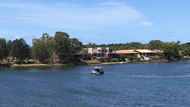 A police boat searching for a man who dived into a creek after attempting to break into a house in Robina.