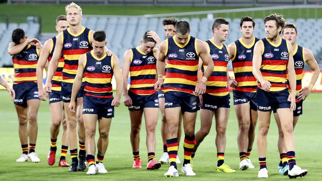 Crows players including Taylor Walker hang their heads after the losing to the Swans in round one Picture Sarah Reed