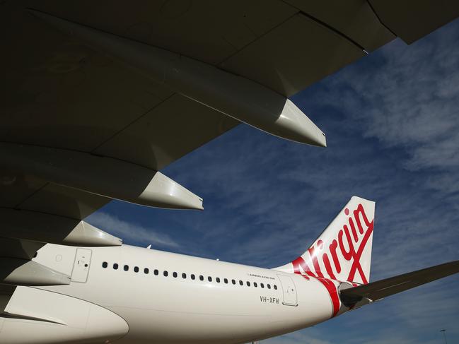 The Virgin Australia Holdings Ltd. logo is displayed on the tail of an Airbus SAS A330 aircraft at Sydney Airport in Sydney, Australia, on Monday, Aug. 17, 2015. Virgin Australia launched its new business-class suites for its A330 fleet. Photographer: Brendon Thorne/Bloomberg