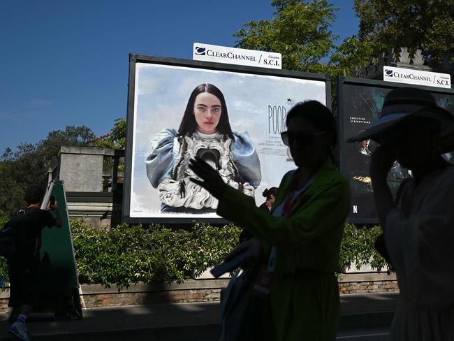 People walk past a poster in Venice showing actor Emma Stone in the movie Poor Things. Picture: Gabriel Bouys/AFP