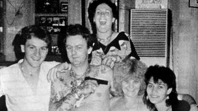 Dennis Allen playfully points a pistol at the head of his mother Kath Pettingill at a party in one of Dennis' houses.