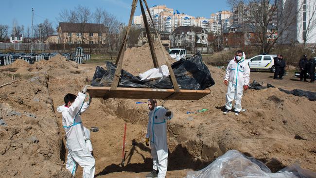 Members of the exhumation team work on a mass grave in Bucha as prosecutors begin investigating allegations of war crimes: Picture: Getty Images.