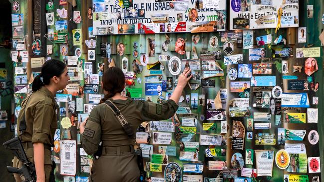 Female Israeli army soldiers view an installation memorialising victims killed at or kidnapped from the Supernova music festival during the October 7 attacks by Palestinian militants, at the festival site near Kibbutz Rein in southern Israel. Picture: AFP