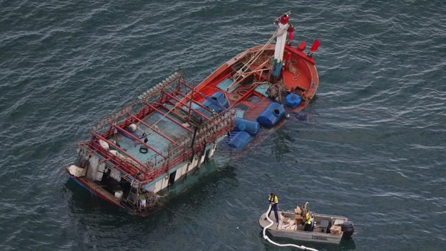 Workers attempt to stem the flow of diesel from the boat, which was spotted off Cape Kimberley in North Queensland. Picture: Marc McCormack