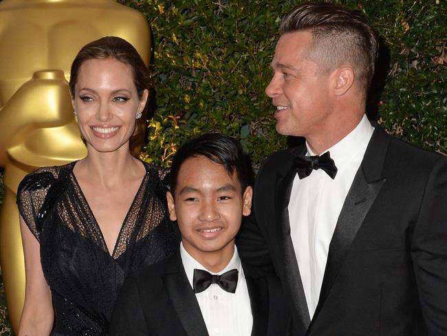 Angelina Jolie, Maddox Jolie-Pitt (C) and Brad Pitt in 2013.