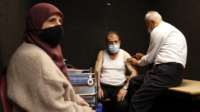 Ali Najdi and wife Nazha receive their Covid-19 vaccination from Dr Jamal Rifi at the Chester Hill Commonwealth Vaccination Clinic in western Sydney on Monday. Picture: Jonathan Ng