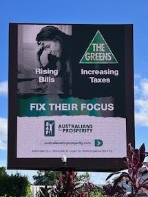 An Australians for Prosperity-funded advertisement displayed on a billboard.