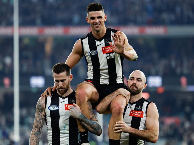 MELBOURNE, AUSTRALIA - AUG 03: Scott Pendlebury of the Magpies is chaired off the ground by teammates Jeremy Howe (L) and Steele Sidebottom (R) after his 400th game during the 2024 AFL Round 21 match between the Collingwood Magpies and the Carlton Blues at The Melbourne Cricket Ground on August 03, 2024 in Melbourne, Australia. (Photo by Dylan Burns/AFL Photos via Getty Images)