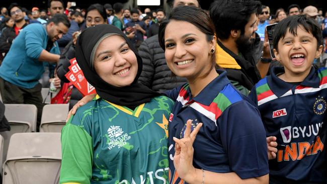 An Indian and Pakistani fan pose together for photographs. Photo by WILLIAM WEST / AFP