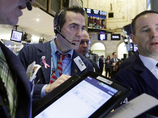 Trader Gregory Rowe, center, and specialist Stephen Naughton, right, work on the floor of the New York Stock Exchange, Wednesday, Feb. 3, 2016. The stock market has given up an early gain and is trading lower at mid-morning Wednesday as investors give a thumbs-down to a number of corporate earnings reports, including steep cutbacks at Yahoo. (AP Photo/Richard Drew)