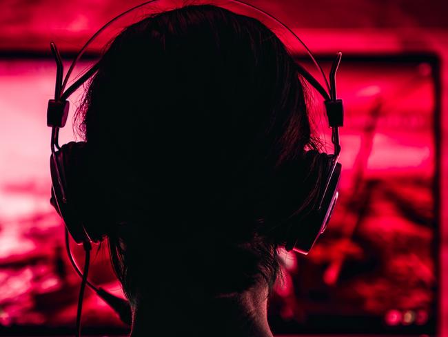 Woman wearing headphones playing video games late at night Picture: Istock