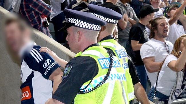 Adelaide United v Melbourne Victory at Coopers Stadium. A Victory fan is escorted from the field. Picture: File