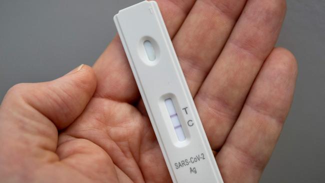 A used rapid antigen test, also known as a lateral flow test showing a positive test result for the Covid-19 coronavirus is photographed in Berlin on January 22, 2022. - Taking a test involves doing swab from inside your nostril or in your throat, depending on the test you are using, before mixing the swab with solution and dripping it onto a container with a test strip with antibodies specific to the Covid-19 virus painted on it in a thin line. If the testing strip detects the virus, it shows up as a red line next to the âTâ on the container, the line next to the âCâshould always be visible. (Photo by Odd ANDERSEN / AFP)